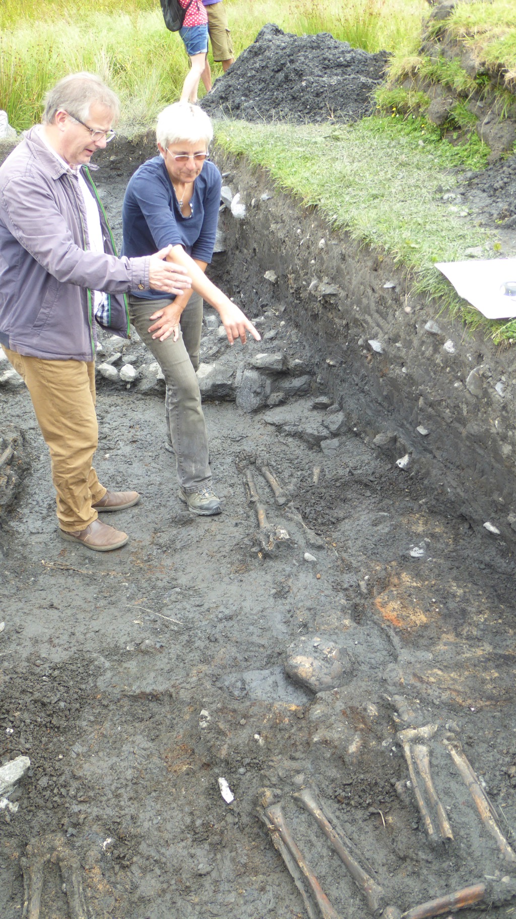 Clare Ellis showing Brendan O’Hara MP the burnt hearth amongst the burials